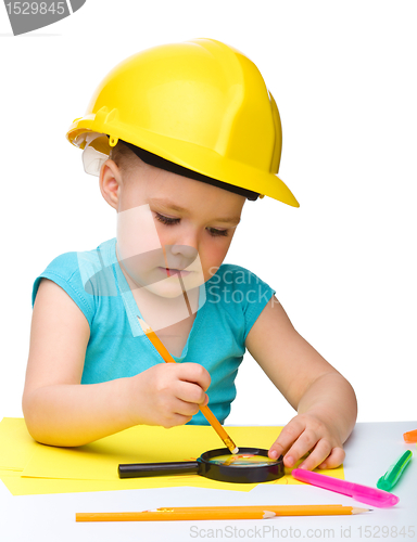 Image of Cute little girl is playing while wearing hard hat