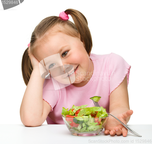 Image of Cute little girl eats vegetable salad