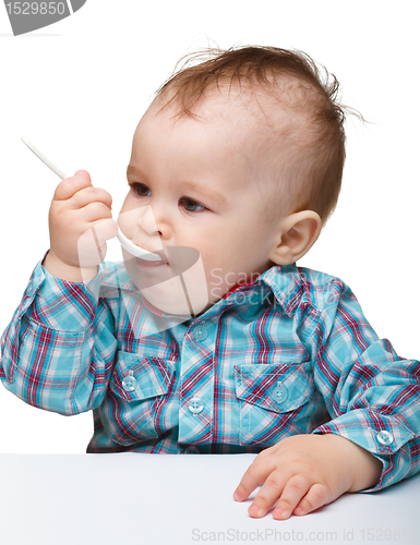 Image of Cute little boy is biting spoon