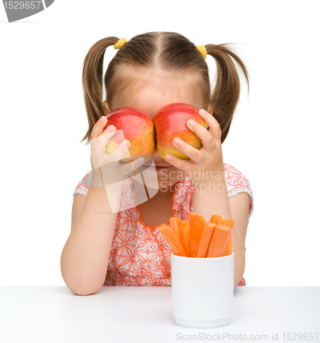 Image of Cute little girl with carrot and apples