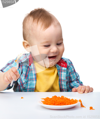 Image of Cute little boy is playing with carrot salad