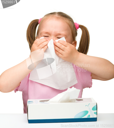 Image of Little girl blows her nose