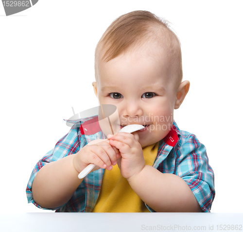 Image of Cute little boy is biting spoon