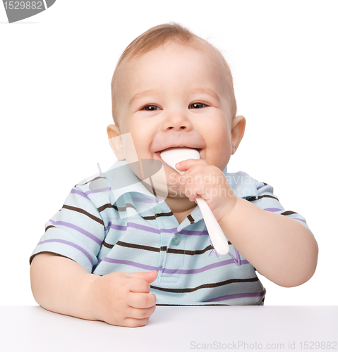 Image of Cute little boy is biting spoon