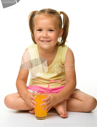Image of Little girl drinks orange juice
