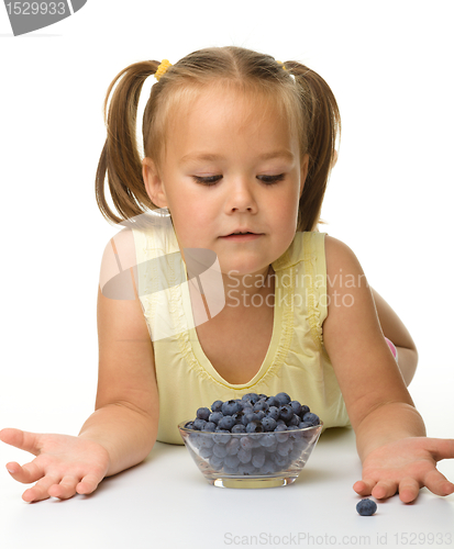 Image of Cute little girl is eating blueberry