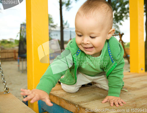 Image of Little boy is playing on playground