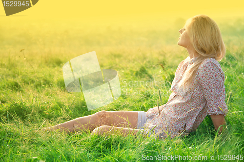 Image of Girl is relaxing on green field