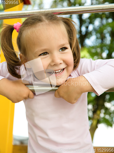 Image of Little girl is playing in playground