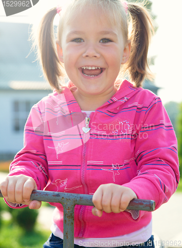 Image of Cute little girl is swinging on see-saw