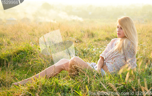 Image of Girl is relaxing on green field