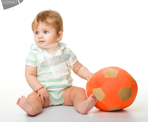 Image of Cute little child is playing with soccer ball