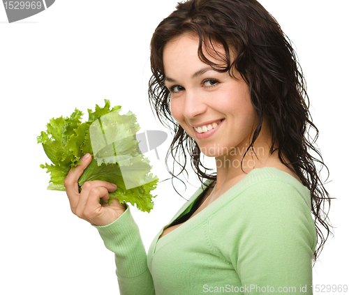 Image of Beautiful young girl with green lettuce leaf