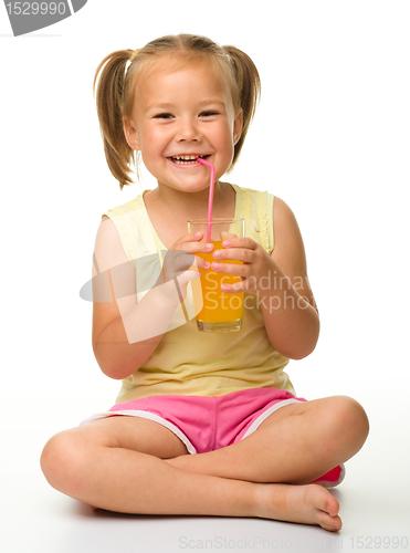 Image of Little girl drinks orange juice