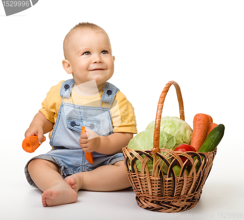 Image of Cute little boy with basket full of vegetables