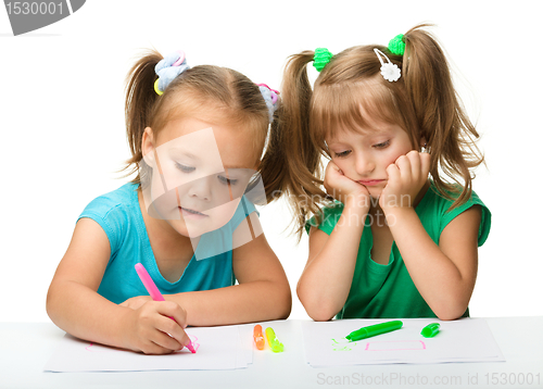 Image of Two little girls draw with markers