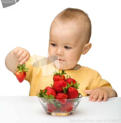 Image of Happy little girl with strawberries