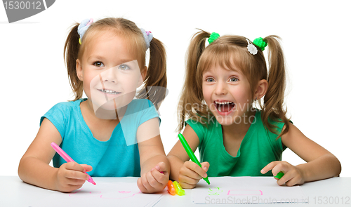 Image of Two little girls draw with markers