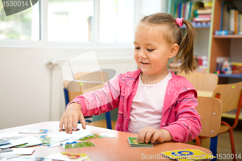 Image of Cute little girl is playing with educational cards