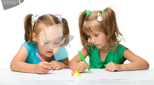 Image of Two little girls draw with markers