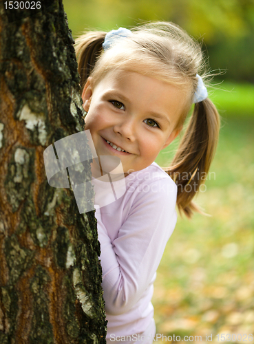 Image of Little girl is playing in autumn park