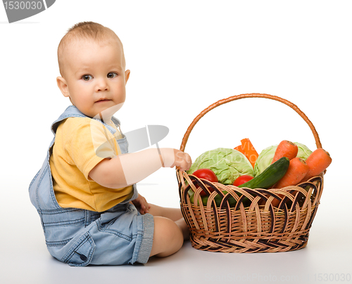 Image of Cute little boy with basket full of vegetables
