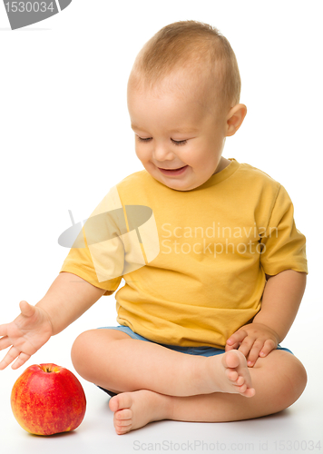 Image of Cheerful little boy with red apple