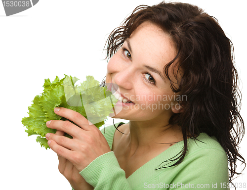 Image of Beautiful young girl with green lettuce leaf