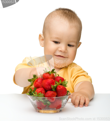 Image of Happy little girl with strawberries