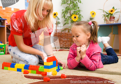 Image of Teacher and child are playing with bricks