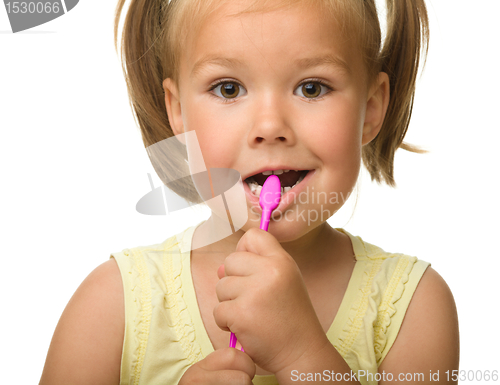 Image of Little girl is cleaning teeth using toothbrush