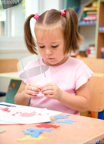 Image of Little girl is playing with plasticine