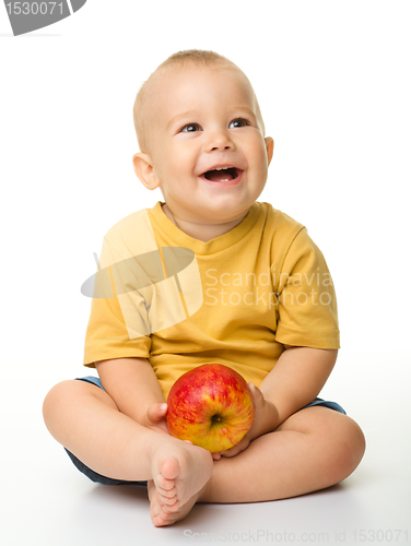 Image of Cheerful little boy with red apple