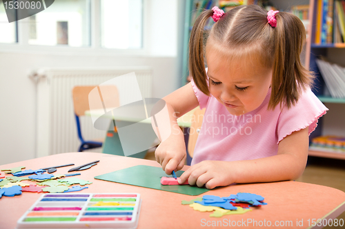 Image of Little girl is playing with plasticine