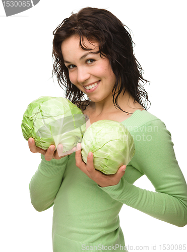 Image of Beautiful young girl with two green cabbages