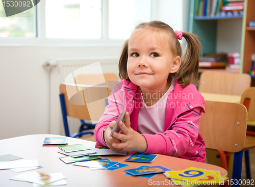 Image of Cute little girl is playing with educational cards