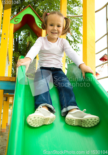 Image of Cute little girl is playing on slider