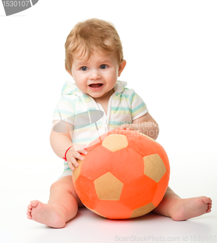 Image of Cute little child is playing with soccer ball