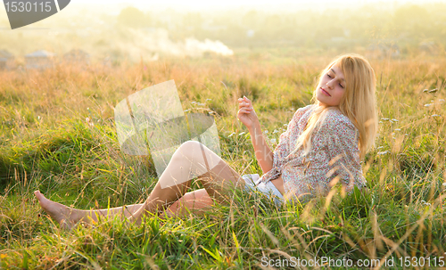 Image of Girl is relaxing on green field