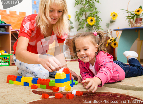 Image of Teacher and child are playing with bricks