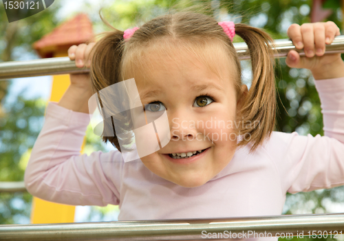 Image of Little girl is playing in playground