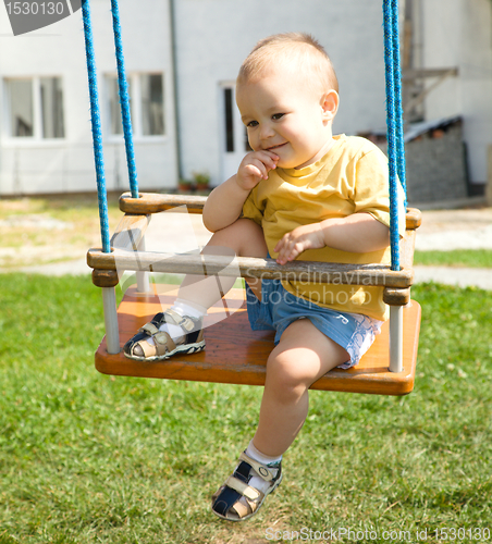 Image of Cute little boy on swing