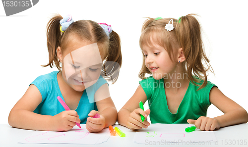 Image of Two little girls draw with markers