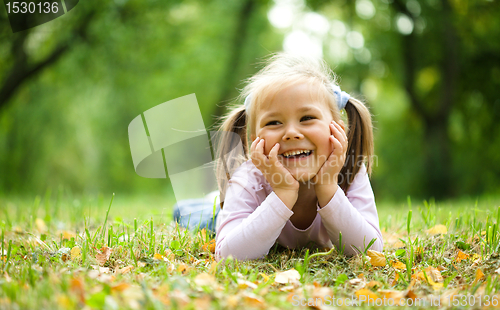 Image of Little girl is playing in autumn park
