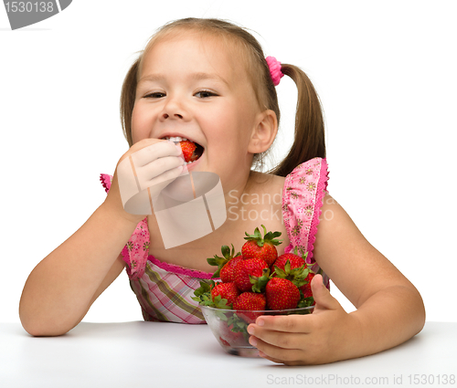 Image of Happy little girl eats strawberries