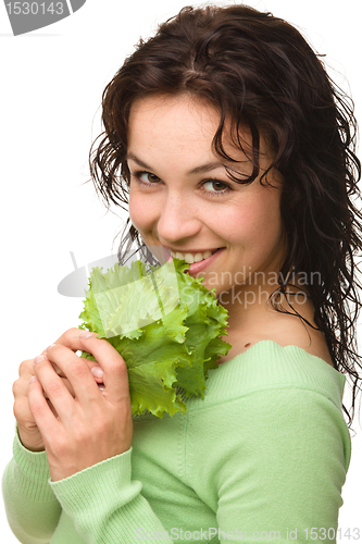 Image of Beautiful young girl with green lettuce leaf