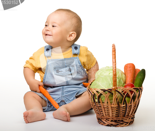 Image of Cute little boy with basket full of vegetables