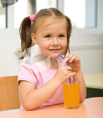 Image of Little girl is drinking orange juice