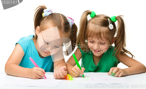 Image of Two little girls draw with markers