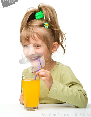 Image of Cute little girl is drinking orange juice